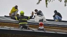 Operai salgono su un tetto per protesta